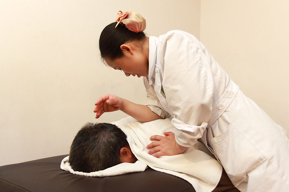 Therapist performing Traditional Chinese massage Tysons Corner, focusing on relaxation, pain relief, and energy balance through ancient healing techniques.